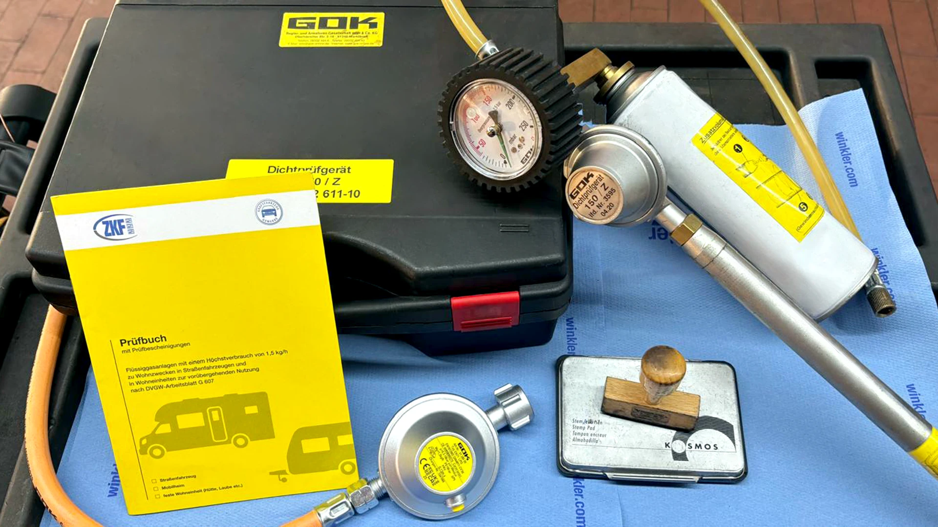Foto zeigt Sonde und Prüfgerät sowie Prüfbuch für die Gasaprüfung bei Campern